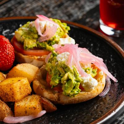English muffins with avocado, tomato slice and pickled red onion