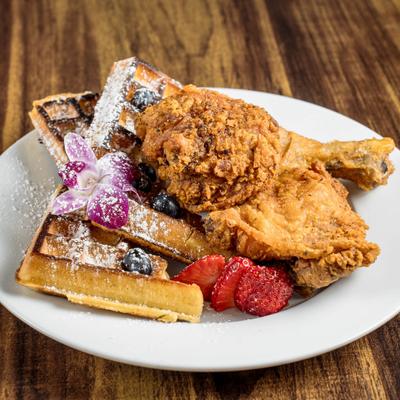 Chicken and Waffles served with berries and dusted with powderd sugar.