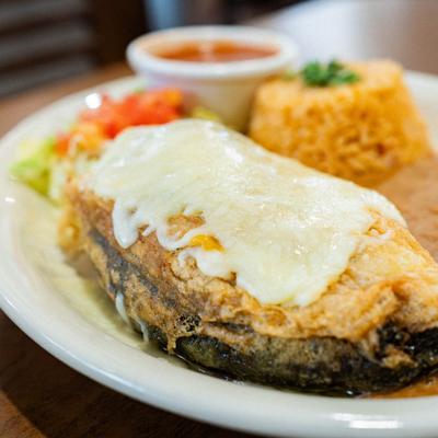 Chile relleno topped with melted cheese served with refried beans, rice, and salsa.