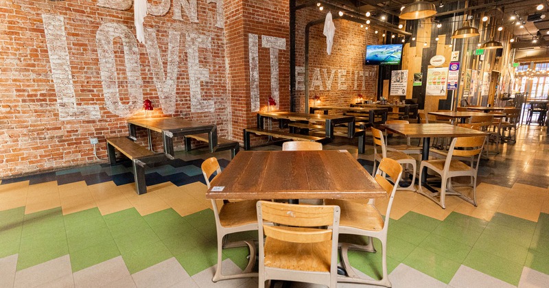 Interior, dining tables and seats, brick wall decorated with large text message