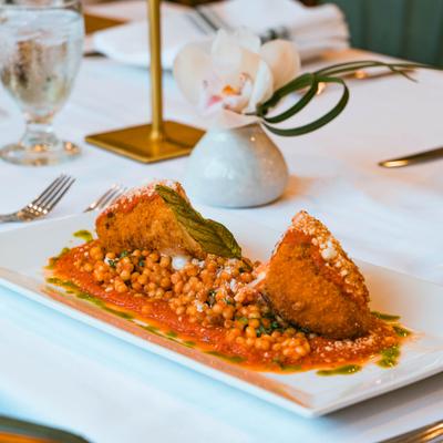 Chicken Parmesan rollatini with fregola sarda pasta and tomato sauce.