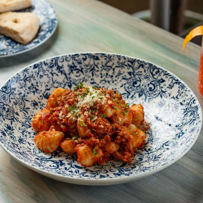 Gnocchi alla Salsiccia - House made potato dumplings, house sweet Sausage Ragu of pork, turkey, tomato, and MoMo spice blend.