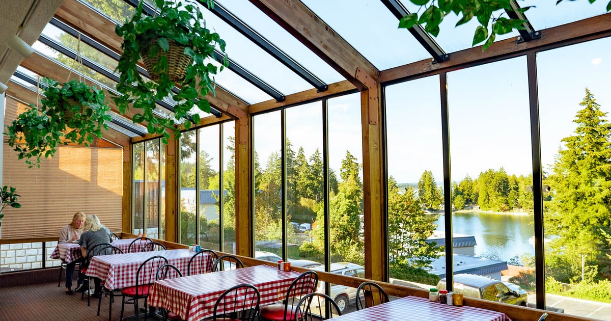 Exterior, tables and chairs lined up next to the windows