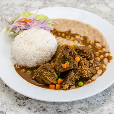 Peruvian beef stew, with rice, beans, and salad.