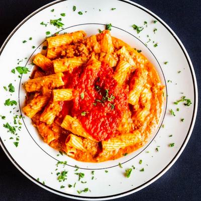 Pasta dish topped with rich tomato sauce and fresh herbs.