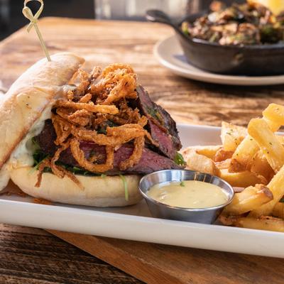 Steak sandwich, with crispy onions, and fries.