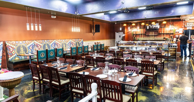 Interior, dining area, wooden tables with chairs for six, long banquette bench with tables