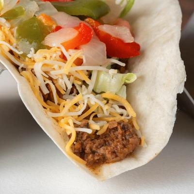 Ground beef taco, with cheese, lettuce, peppers, onion, and tomato.