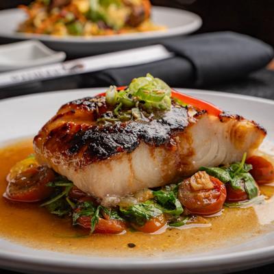 Miso Black Cod served over a bed of sautéed vegetables.
