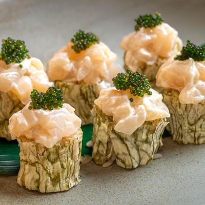 Scallop sushi rolls topped with green caviar.