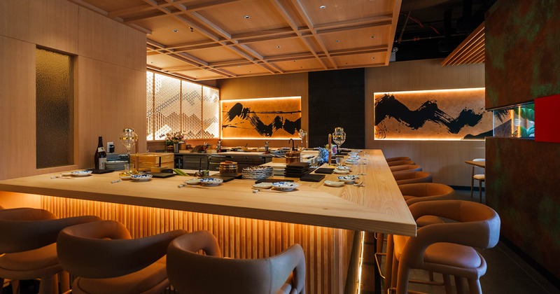 Interior, hibachi bar with padded stools, wooden top, set up and ready for guests