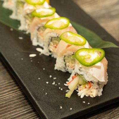 Yellowtail, spicy crab, cucumber, and avocado rolls, topped with peppers.
