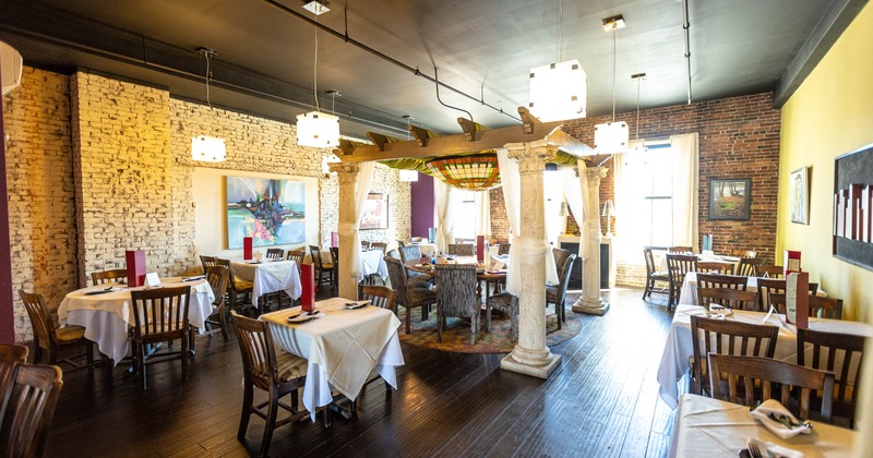 Interior, seating area, indoor pergola with large round table, wooden flooring, brick walls