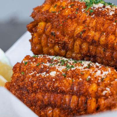 A close-up of spicy street corn on the cob.
