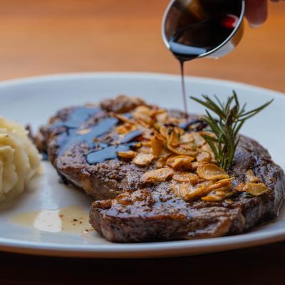 Ribeye steak topped with crispy garlic and sauce, served with mashed potatoes.