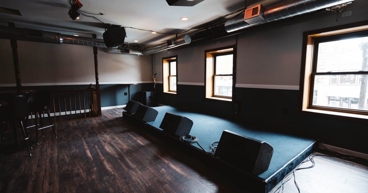 Interior, darkly lit seating area, TVs on the wall