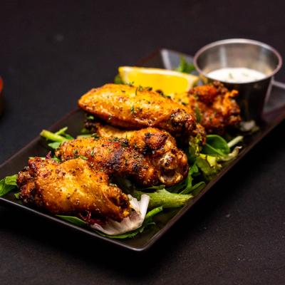 Plate of Lemon Pepper Wings served with a dip.