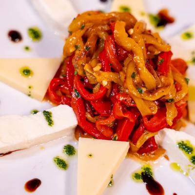 Roasted red and yellow peppers in the center, surrounded by cheese wedges.