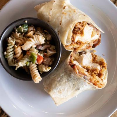 Chicken cordon bleu wrap with a cup of pasta salad.
