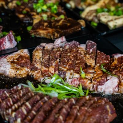 Premium sliced medium-rare beef steak garnished with fresh chopped green onions.