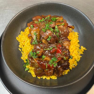 Slow-cooked oxtail served over yellow rice.