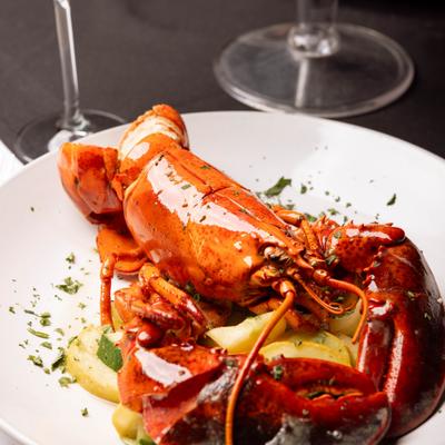 Steamed whole lobster on a plate with herbs.