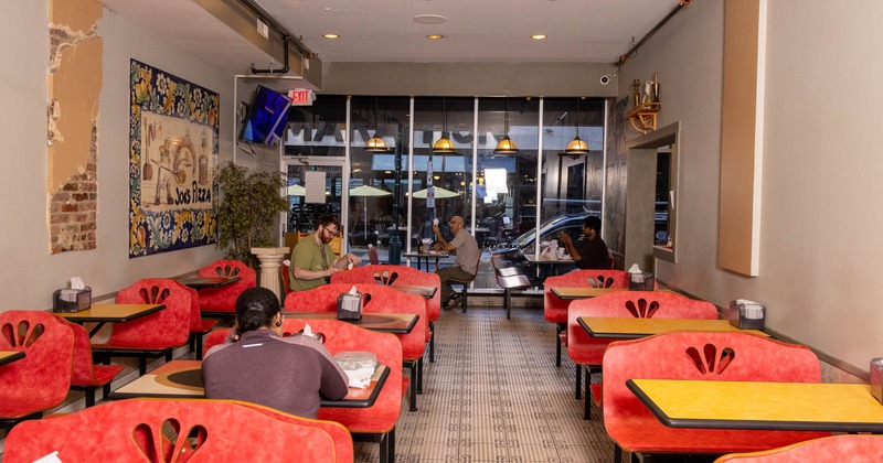 Interior, tables and benches lined up, guests sitting and chatting