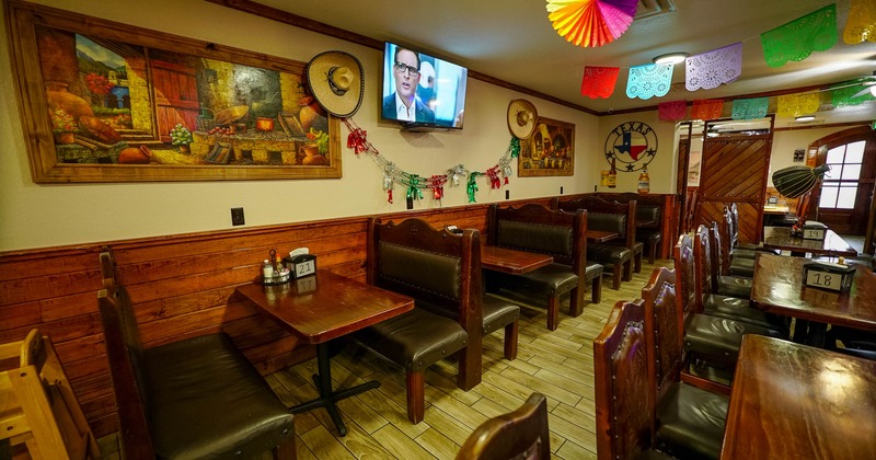 Interior of a restaurant with booths, festive decorations, and a TV