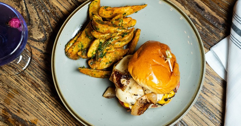 Bacon Angus cheeseburger served with chimichurri potato wedges