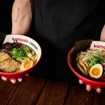 Person holding two bowls with food.