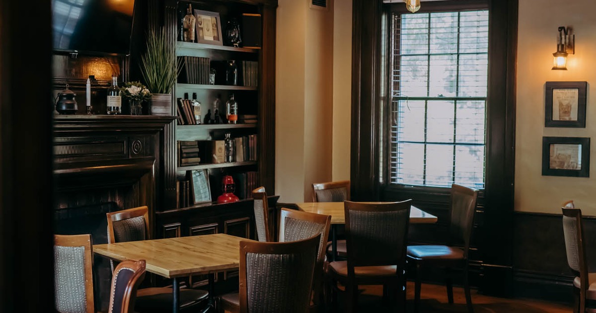 Interior, tables, chairs and book shelves on the wall