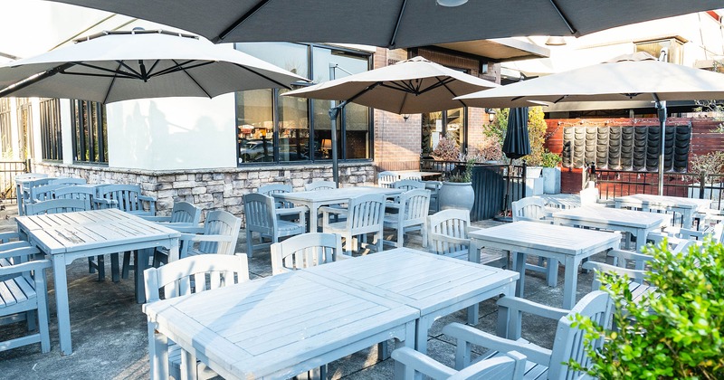 Patio, seating area with tables, chairs and garden umbrellas