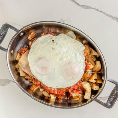 Hash skillet topped with corned beef and fried eggs.