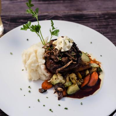 Filet Mignon topped with butter, served with mashed potaoes and vegetables.