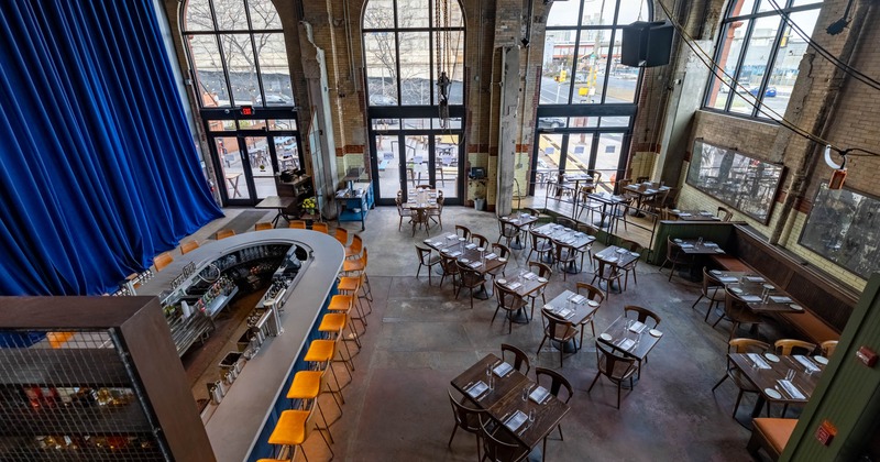 Interior, wooden banquette seating bench, tables and chairs, concrete floor