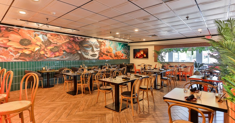 Dining area decorated with a large mural art, set tables ready for guests