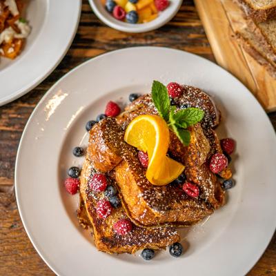 Cinnamon French toast served with syrup, butter and fresh berries