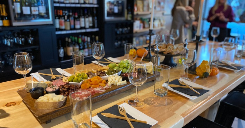 Fully set table, with charcuterie board, glasses, napkins, and utensils