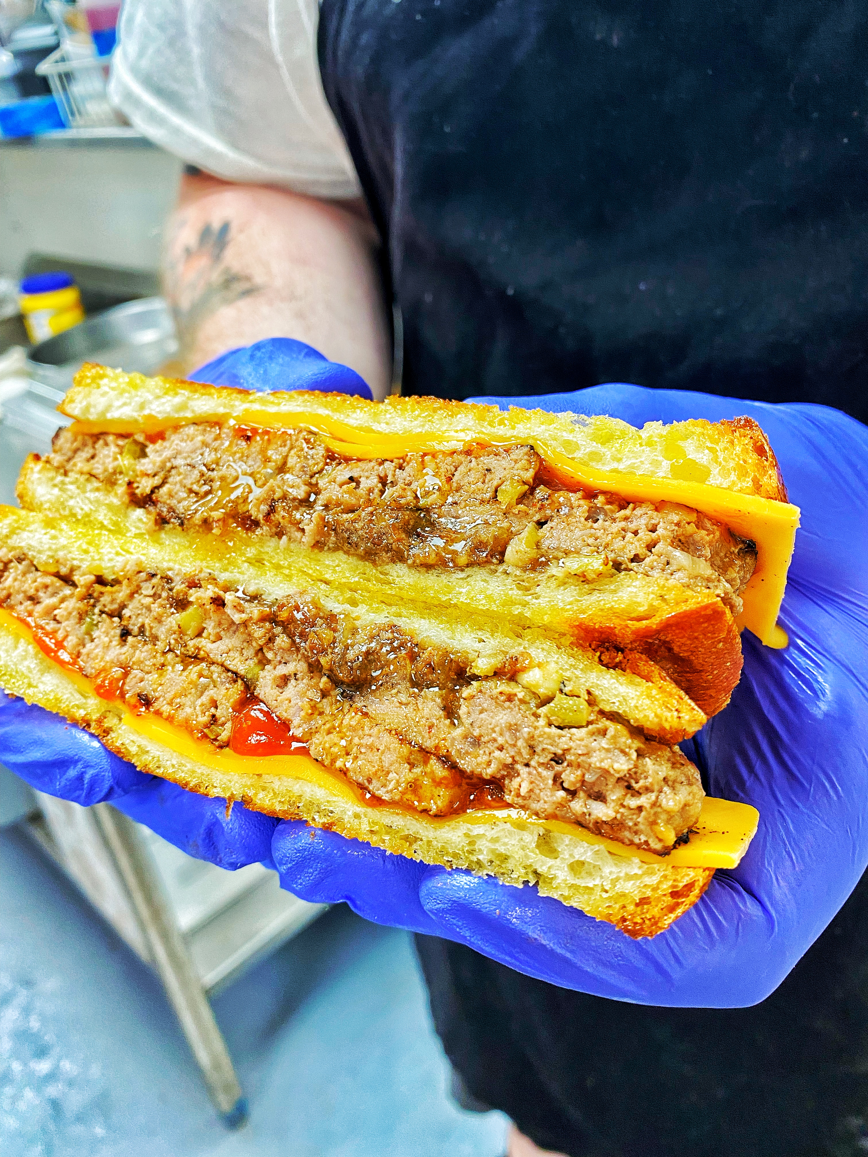 Picture of a meatloaf sandwich in a cook's hands