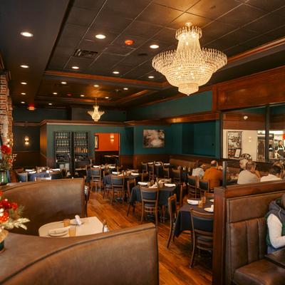 Elegant interior featuring chandeliers, leather booths, and dark wood accents.