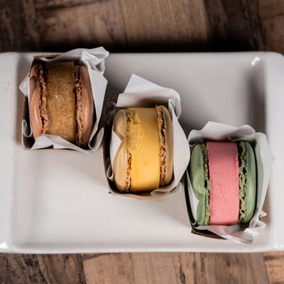 Macaron ice cream sandwiches served on a white plate.