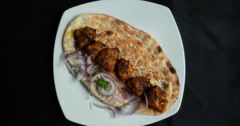 Chicken kabob served on naan bread with onions