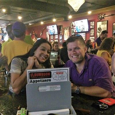 A guy in a purple jersey and a smiling girl posing for a photo and sitting