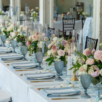 A beautifully set long table with place settings and floral display.