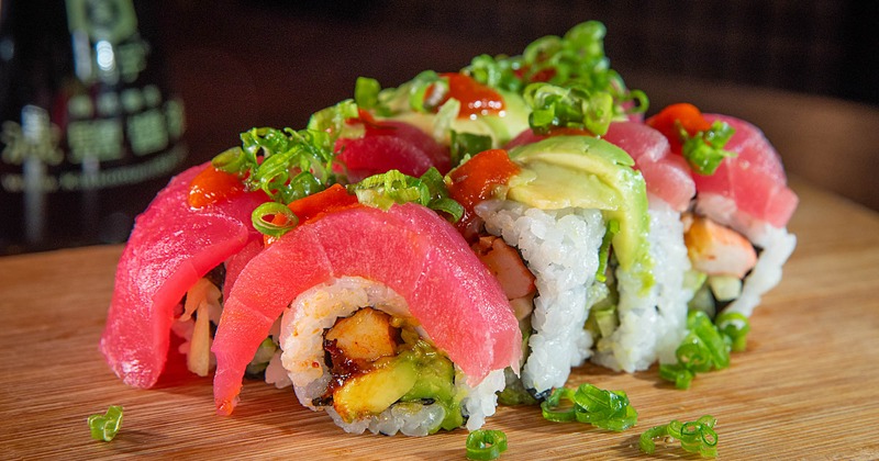 Sushi rolls topped with tuna and avocado
