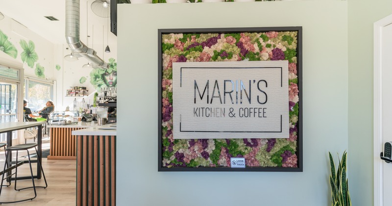 Interior, sign on the wall, diner area on a side, people