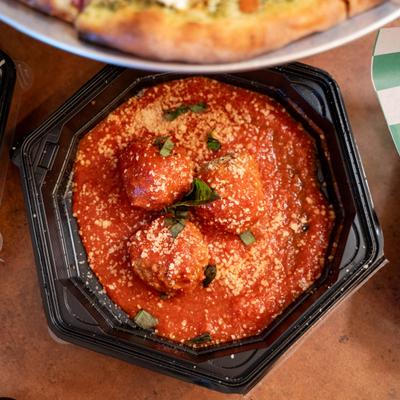 Mama's Meatball Bites served in a black take-out container.