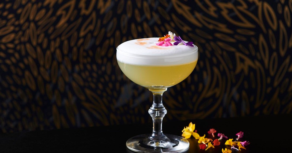 Whiskey sour cocktail garnished with flowers