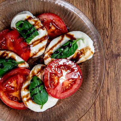 Caprese salad with fresh basil and balsamic glaze, top view.