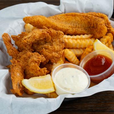 Fried fish and shrimp basket with fries, two dips and lemon wedges.